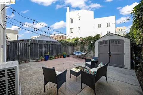 a view of a patio with table and chairs with wooden fence and plants