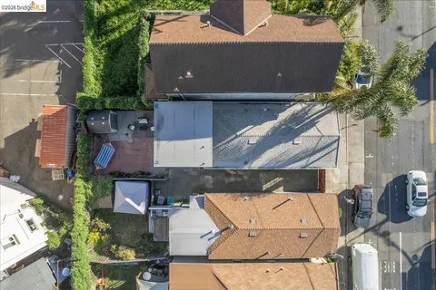 an aerial view of a house with a yard and large tree