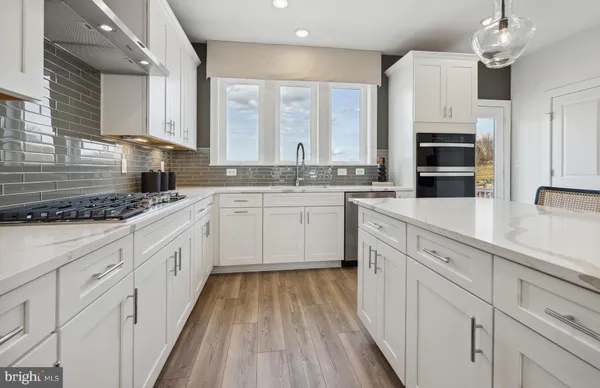 a kitchen with stainless steel appliances kitchen island granite countertop a stove sink and cabinets