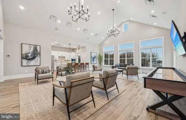 a living room with furniture kitchen view and a chandelier