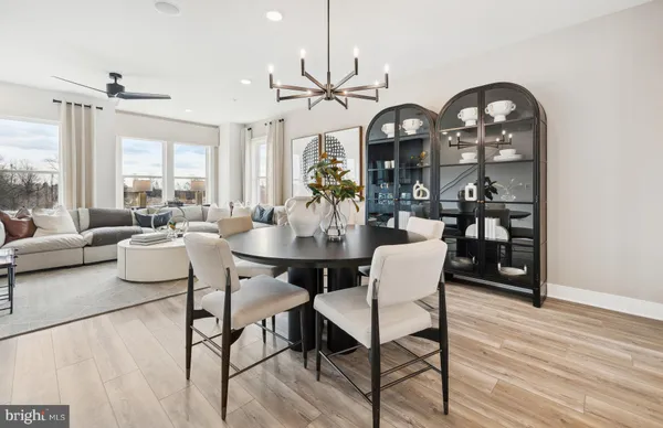 a dining room with wooden floor a chandelier a wooden table and chairs