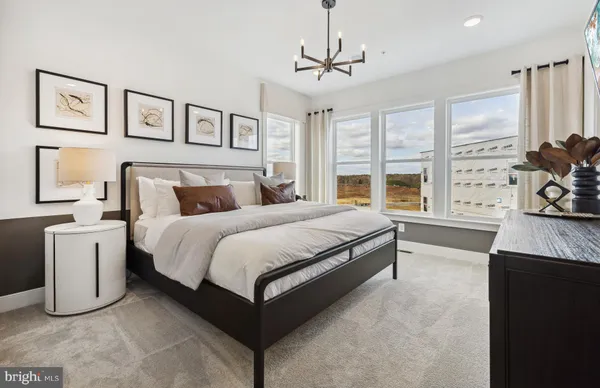a spacious bedroom with a bed and a flat screen tv