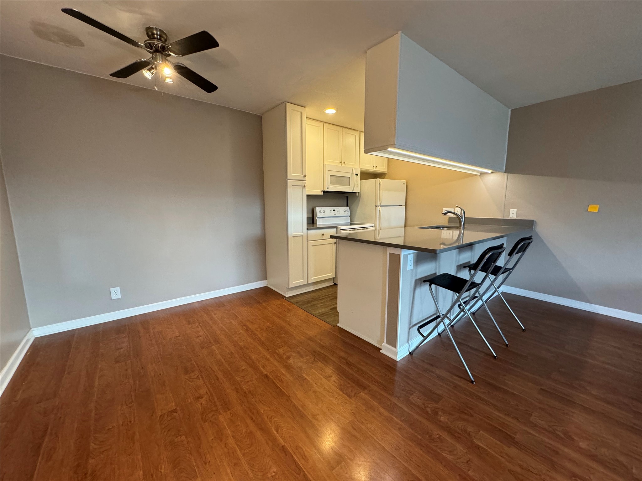 910 Duncan Lane, Unit 43 Austin, TX 78705 - Photo 3 of 15 a workspace with wooden floor and a chandelier fan