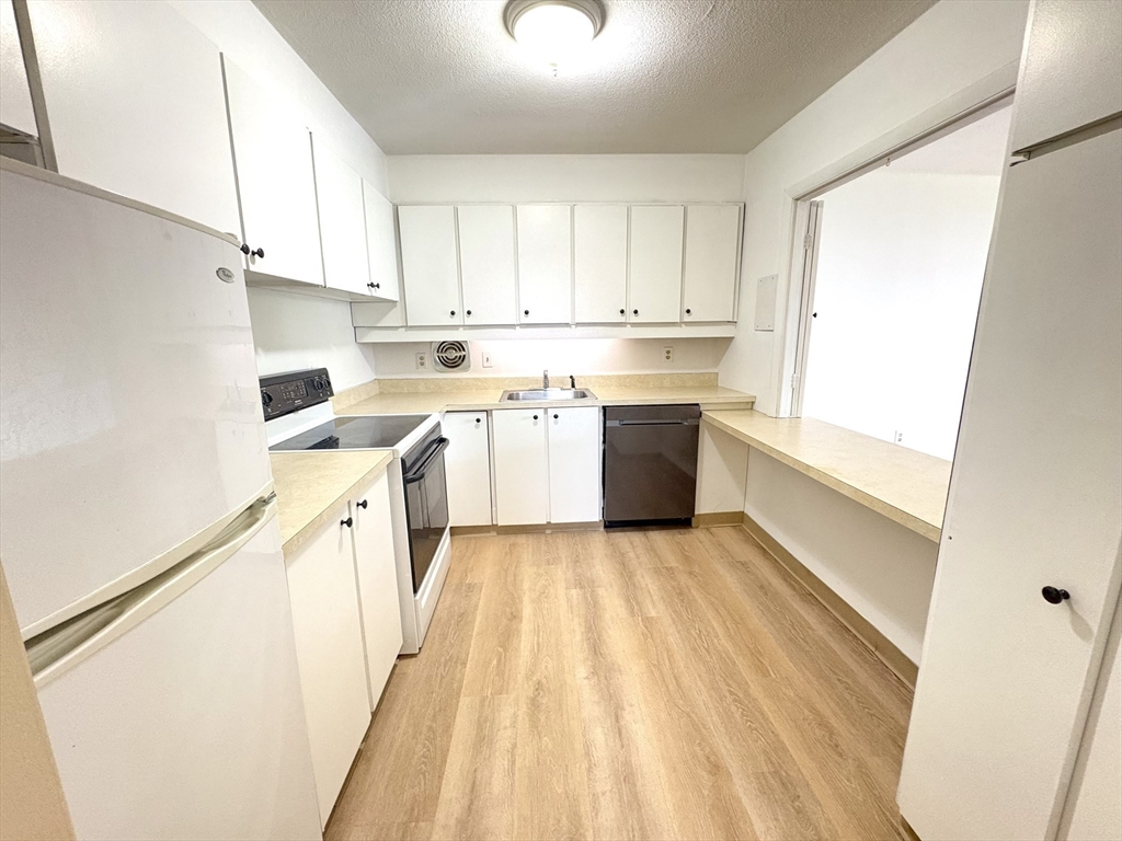 80 Salisbury Street, Unit 308 Worcester, MA 01609 - Photo 7 of 25 a kitchen with a sink a stove and cabinets