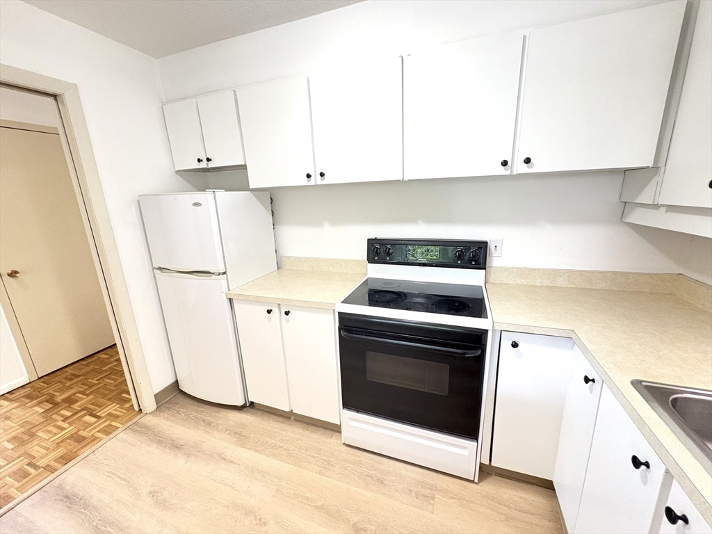 80 Salisbury Street, Unit 308 Worcester, MA 01609 - Photo 9 of 25 a kitchen with white cabinets and white appliances