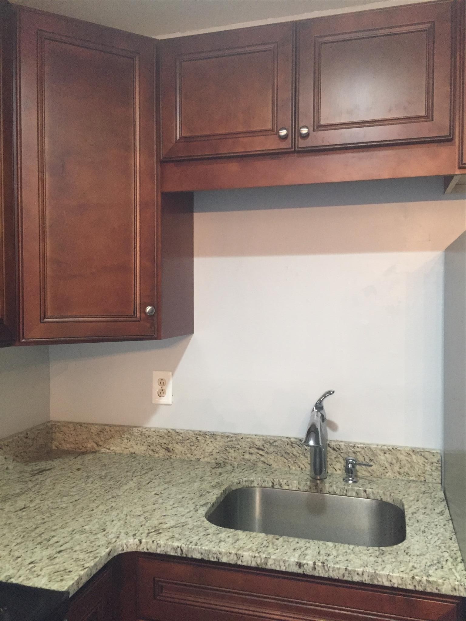 370 Wallace Road, Unit F9 Nashville, TN 37211 - Photo 6 of 14 a kitchen with granite countertop a sink and cabinets