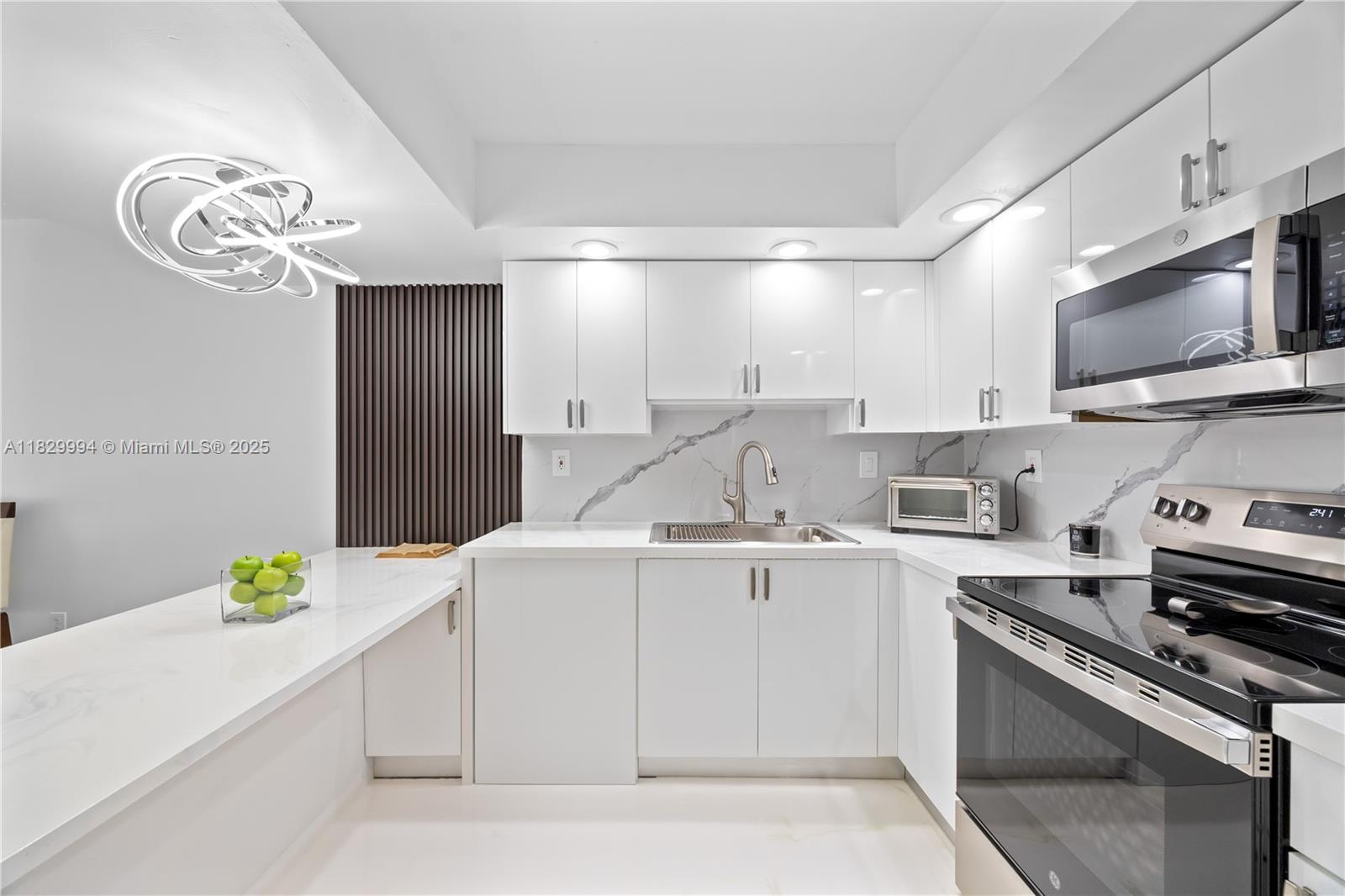 a kitchen with a sink a stove cabinets and wooden floor