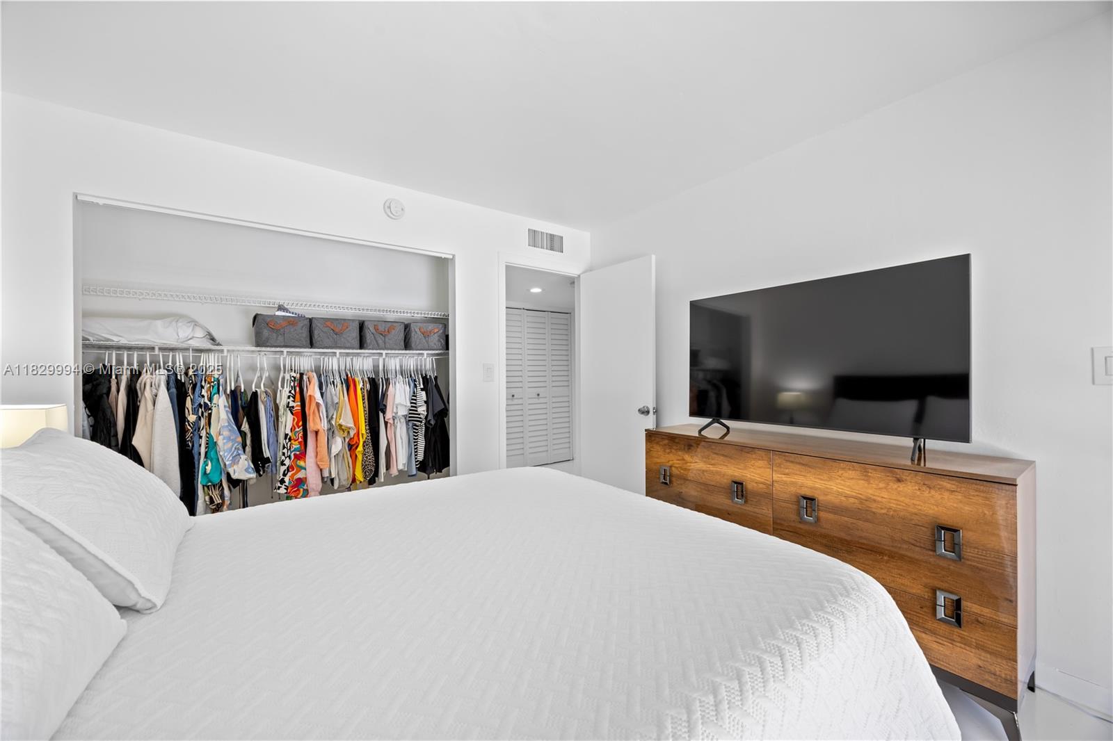 8810 Southwest 132nd Place, Unit 101DN Miami, FL 33186 - Photo 16 of 39 a bedroom with a bed and a flat screen tv