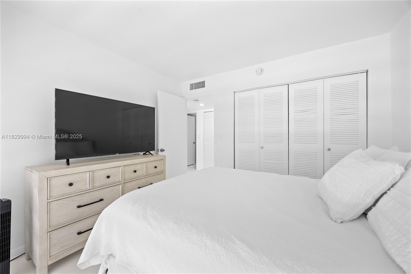 8810 Southwest 132nd Place, Unit 101DN Miami, FL 33186 - Photo 19 of 39 a bedroom with a bed and a flat screen tv