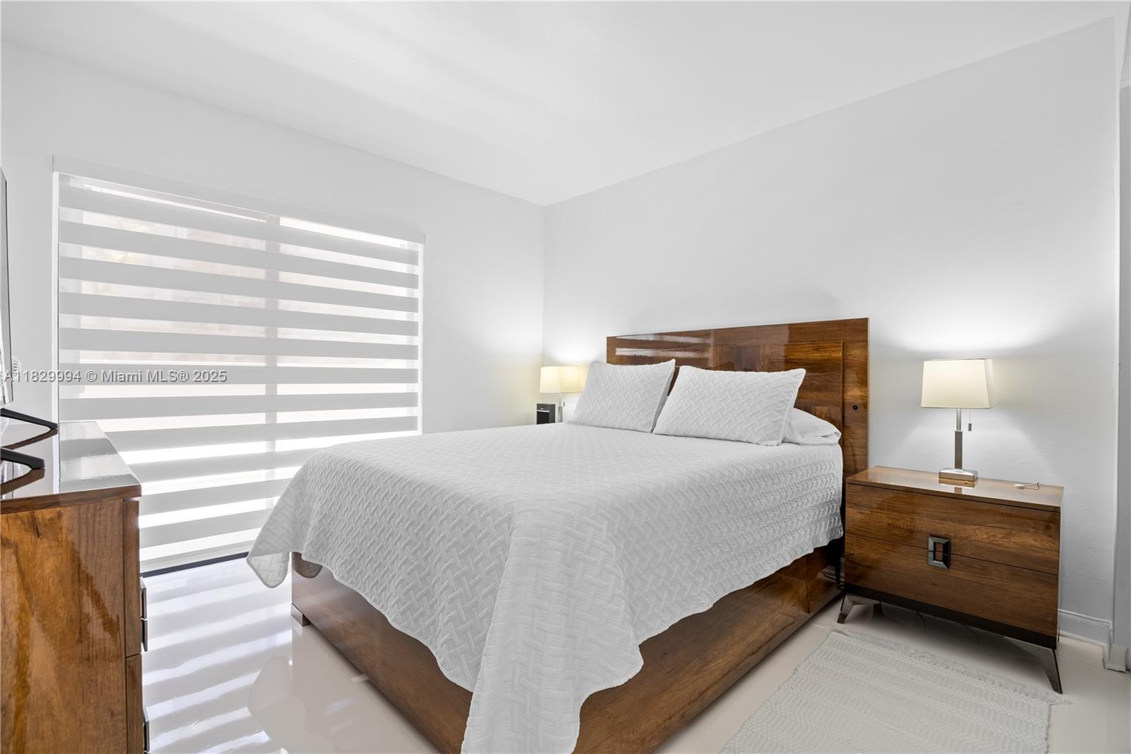 8810 Southwest 132nd Place, Unit 101DN Miami, FL 33186 - Photo 4 of 39 a bedroom with a bed and a night stand