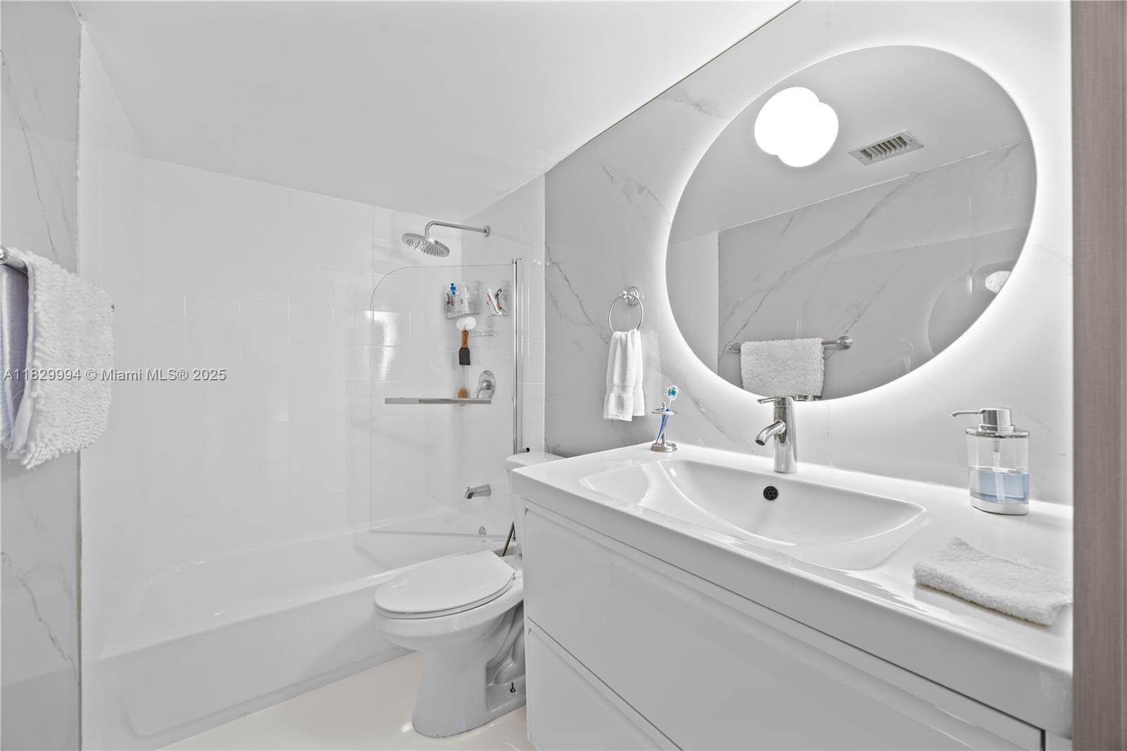 8810 Southwest 132nd Place, Unit 101DN Miami, FL 33186 - Photo 6 of 39 a bathroom with a sink a toilet and a mirror