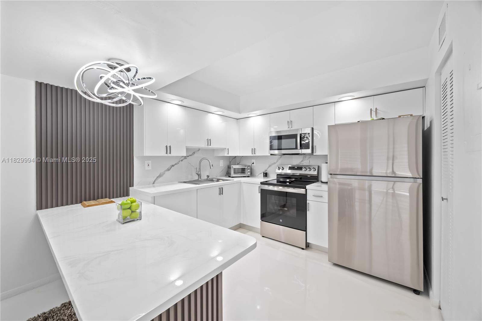 8810 Southwest 132nd Place, Unit 101DN Miami, FL 33186 - Photo 8 of 39 a kitchen with refrigerator cabinets and wooden floor