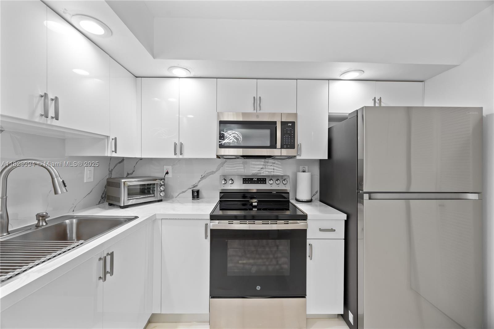 8810 Southwest 132nd Place, Unit 101DN Miami, FL 33186 - Photo 9 of 39 a kitchen with a refrigerator stove and sink