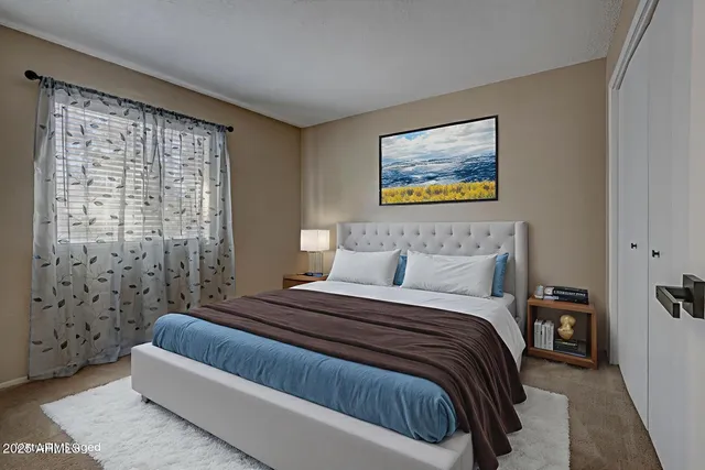 a bedroom with a bed and a painting on the wall