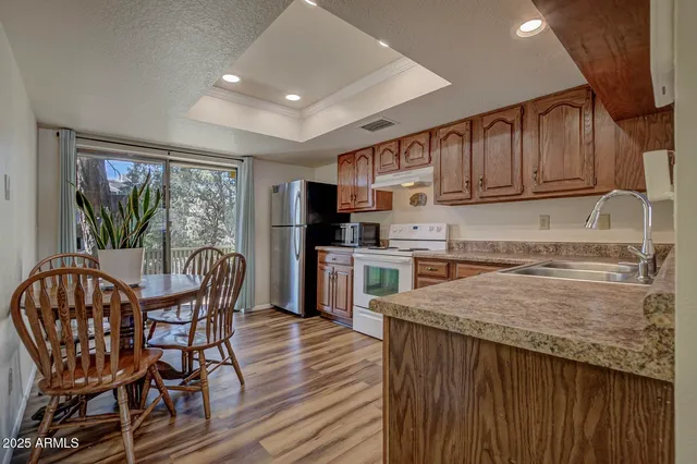 a kitchen with stainless steel appliances granite countertop a kitchen island hardwood floor and a sink