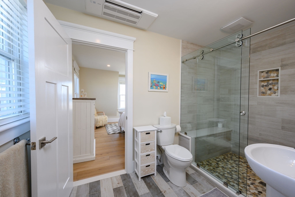 133 Beach Avenue Hull, MA 02045 - Photo 23 of 42 a bathroom with a granite countertop toilet a sink and shower