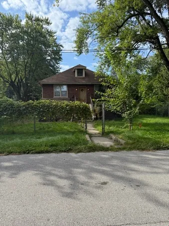 a view of a house next to a yard with big trees