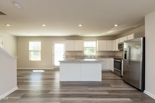 a kitchen with stainless steel appliances granite countertop a refrigerator and a sink