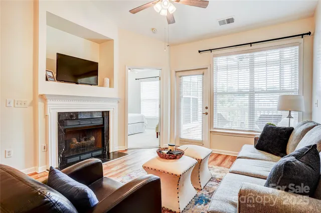 a living room with furniture a flat screen tv and a fireplace