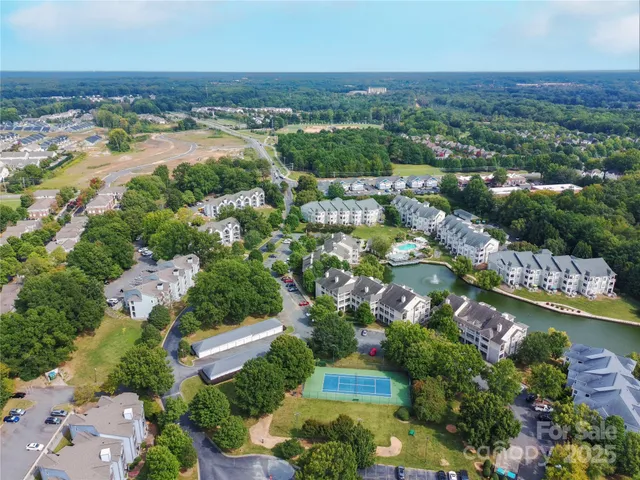 an aerial view of a city with lots of residential buildings ocean and mountain view in back
