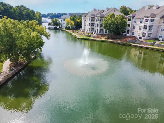 an aerial view of residential houses with outdoor space and lake view