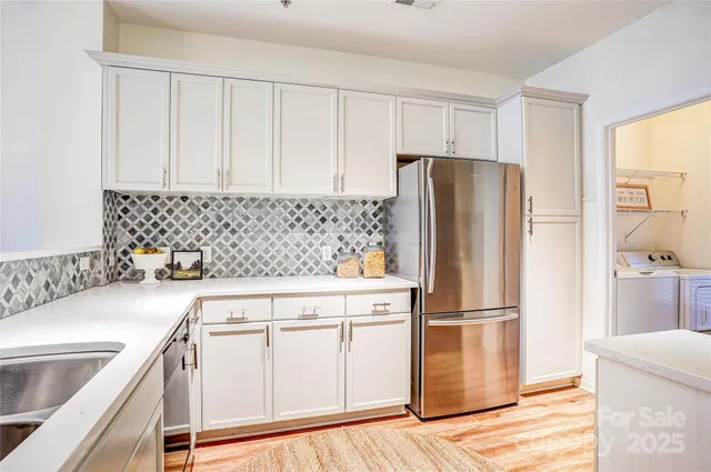 a kitchen with stainless steel appliances granite countertop a refrigerator sink and white cabinets