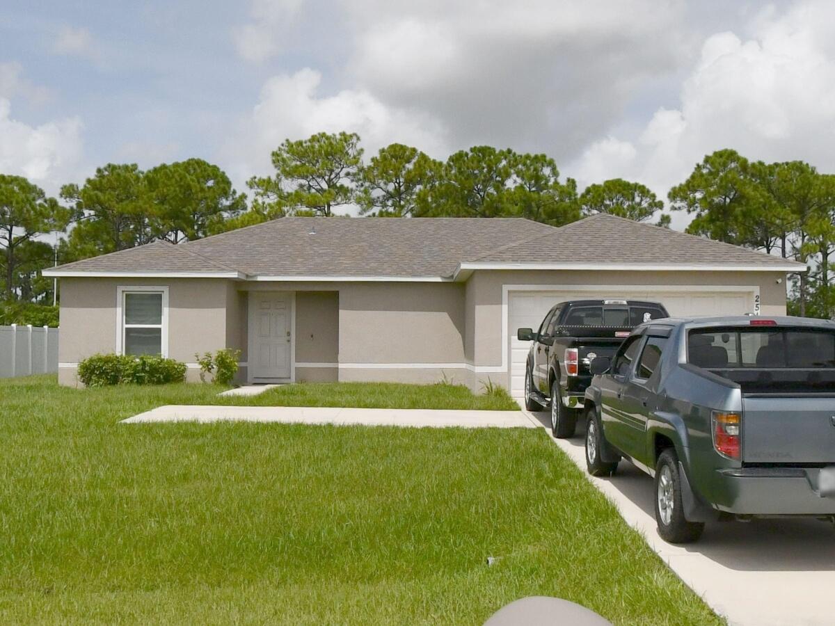 2514 Southwest Savage Boulevard Port St. Lucie, FL 34953 - Photo 1 of 19 a front view of a house with a yard and garage