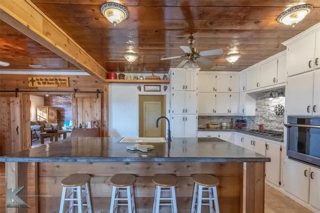 a kitchen with a table chairs microwave and cabinets