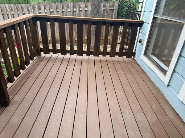 a view of a house with a small yard plants and wooden fence
