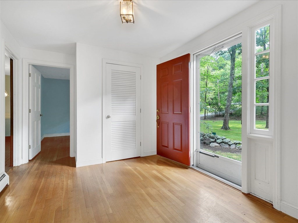 70 Parsonage Lane Topsfield, MA 01983 - Photo 7 of 29 an empty room with large windows and wooden floor