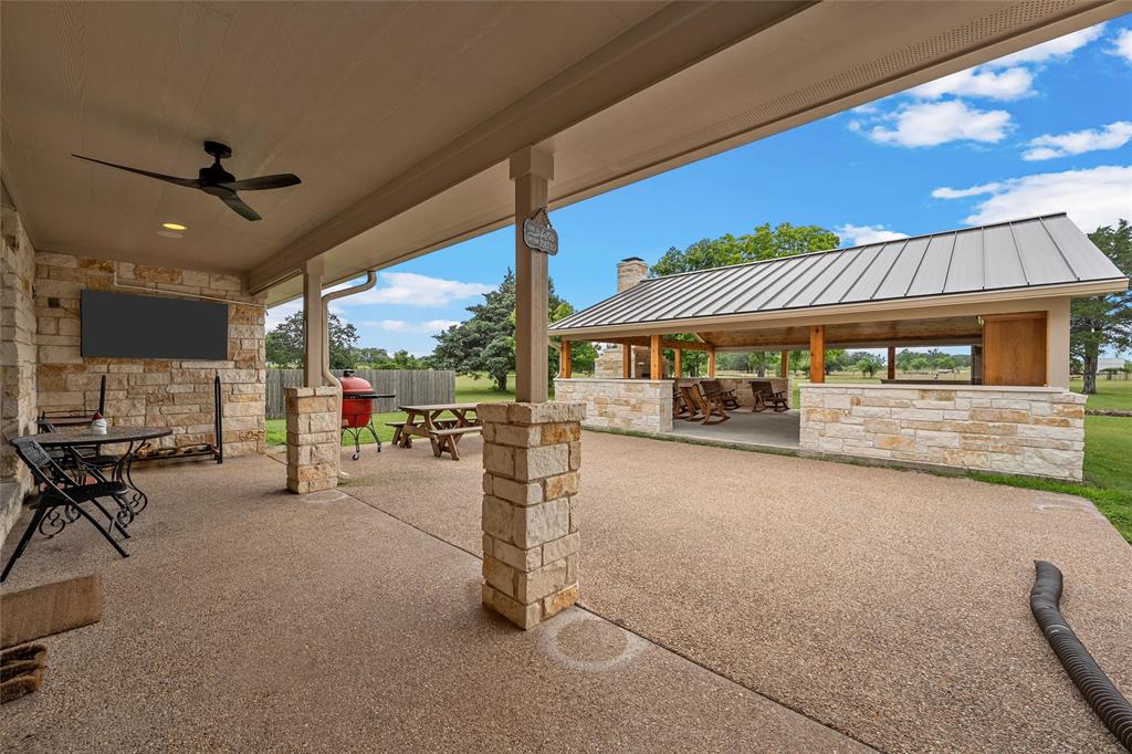 1117 Downsville Road Robinson, TX 76706 - Photo 25 of 40 Spacious covered patio with stone facade wall, ceiling fan, and recessed lighting
