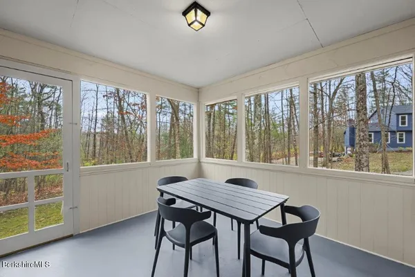a view of a dining room with furniture large windows and wooden floor