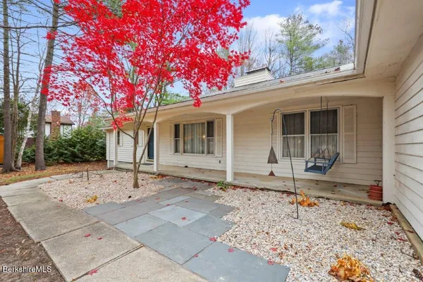 a front view of a house with a tree