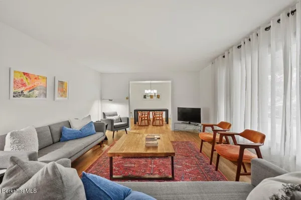a living room with furniture a rug and a flat screen tv