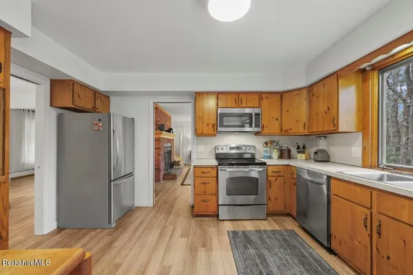 a kitchen with stainless steel appliances granite countertop a refrigerator stove top oven and sink
