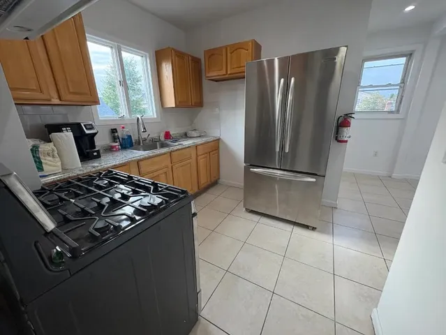 a kitchen with stainless steel appliances granite countertop a refrigerator stove and sink