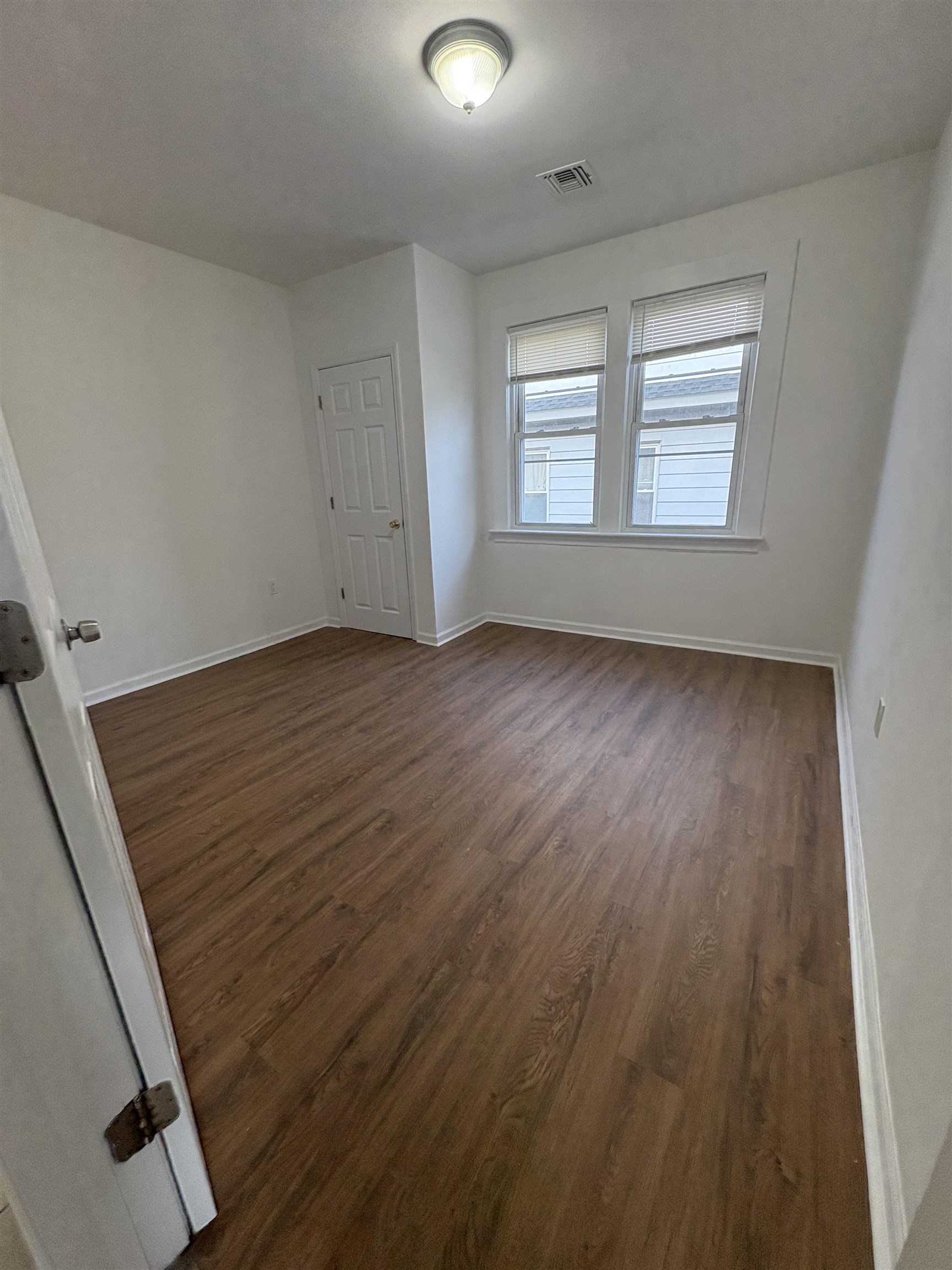 355 Princeton Avenue, Unit 2 Hillside, NJ 07205 - Photo 6 of 11 a view of an empty room with wooden floor and a window