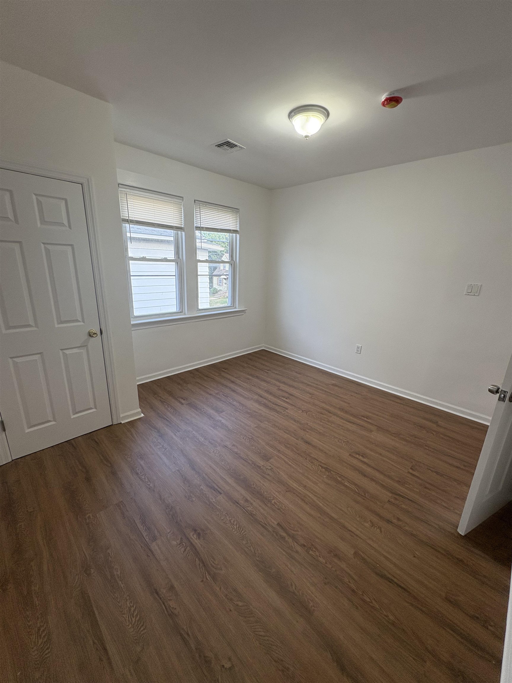 355 Princeton Avenue, Unit 2 Hillside, NJ 07205 - Photo 8 of 11 an empty room with wooden floor and windows