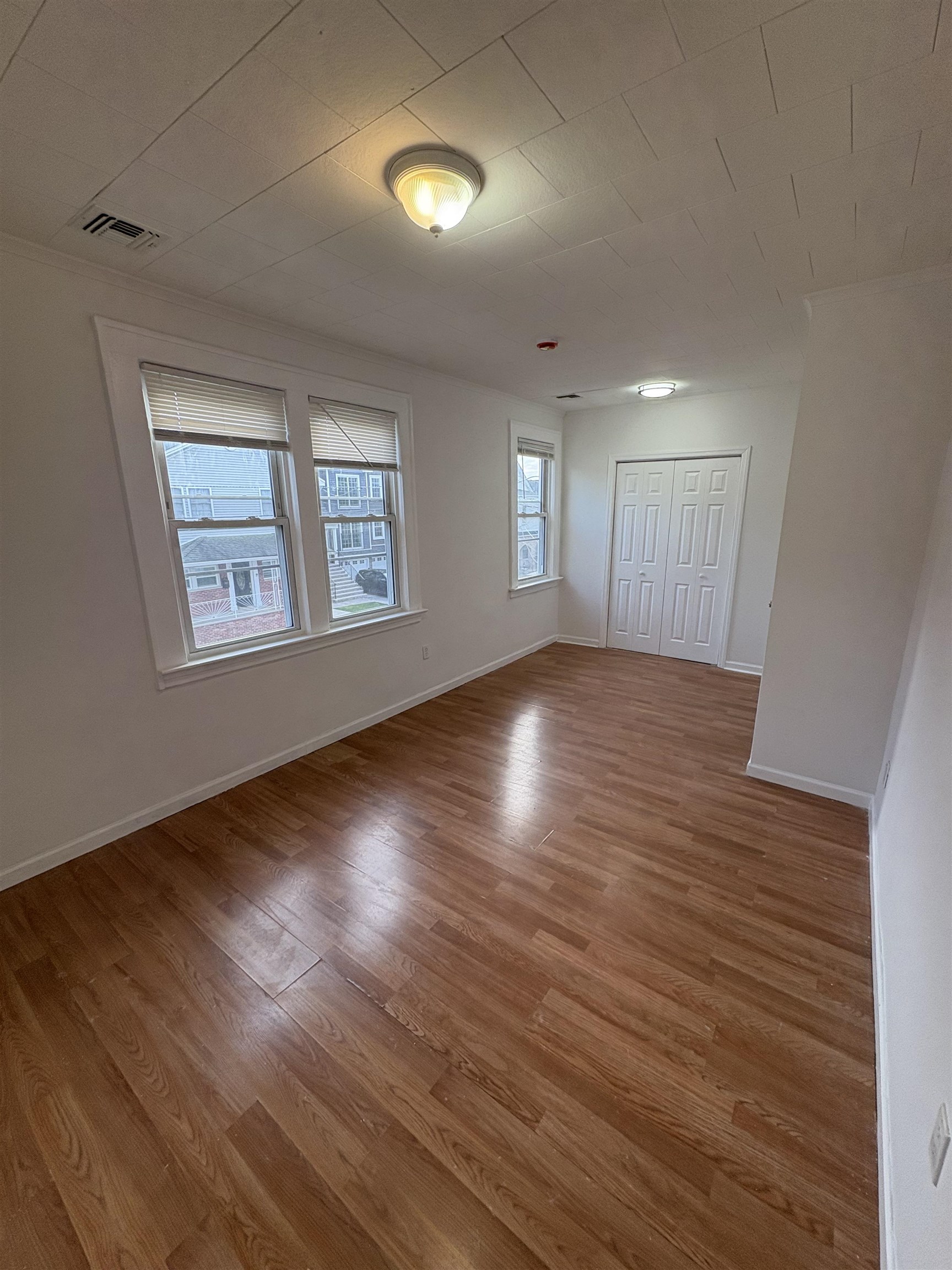 355 Princeton Avenue, Unit 2 Hillside, NJ 07205 - Photo 10 of 11 an empty room with wooden floor and windows