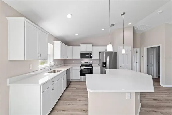 a large kitchen with kitchen island a sink stainless steel appliances and cabinets