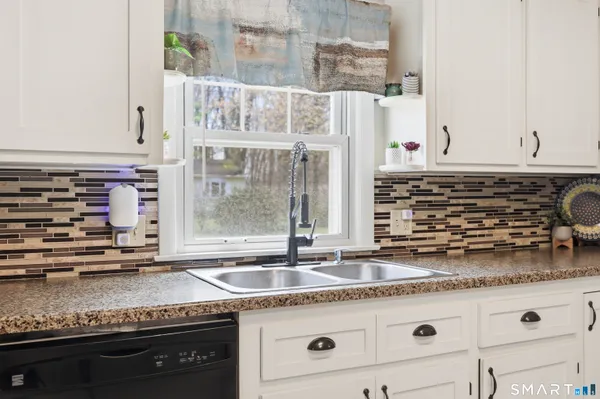 a kitchen with granite countertop a sink and a stove