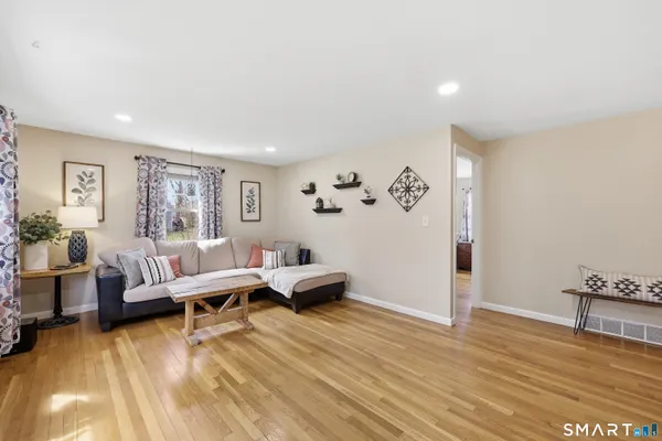 a living room with furniture and wooden floor