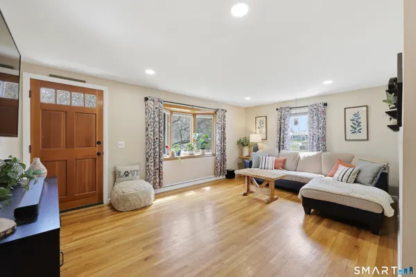 a living room with furniture and a wooden floor