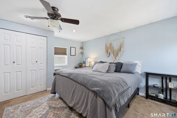 a bedroom with a bed and a painting on the wall