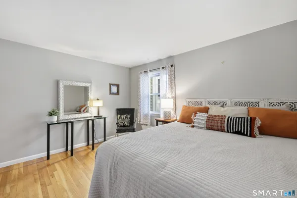a bedroom with a bed and wooden floor