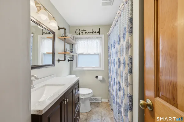 a bathroom with a granite countertop sink and a shower curtain