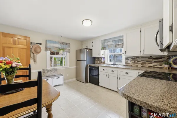 a kitchen with granite countertop a sink stove and refrigerator