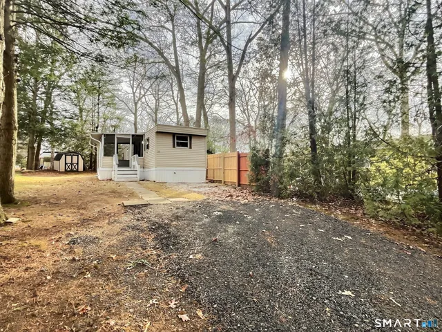 a view of house with yard and trees