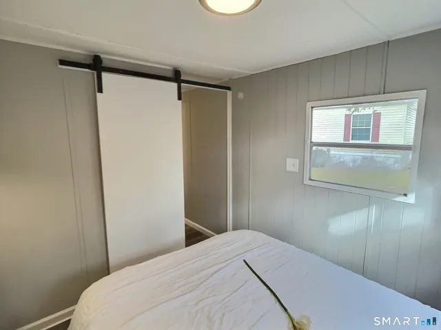 a bedroom with a bed and a window