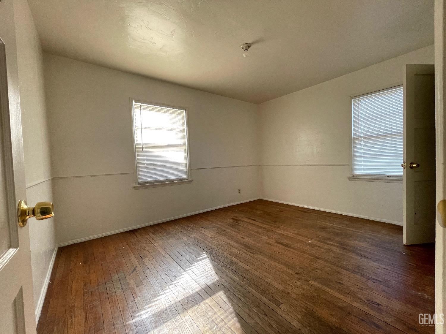 Undisclosed Address Bakersfield, CA 93304 - Photo 16 of 17 an empty room with wooden floor and windows